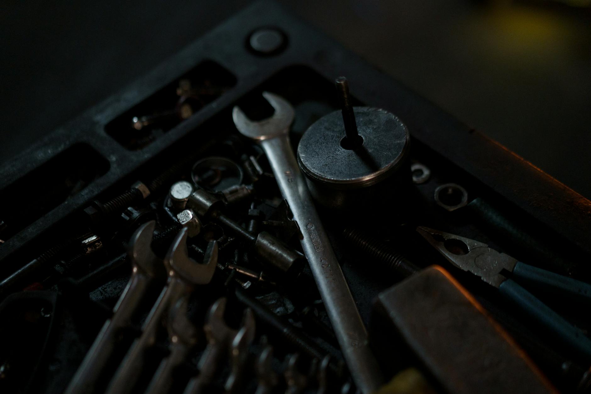 Wide documentary shot of a toolbox with plumbing tools laid out